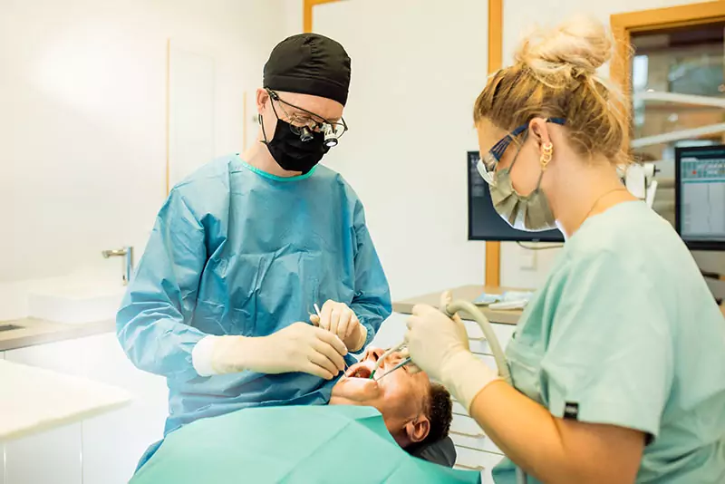 forst42 Zahnarzt Brieselang ZMA und Zahnarzt untersuchen Patienten auf Behandlungsstuhl